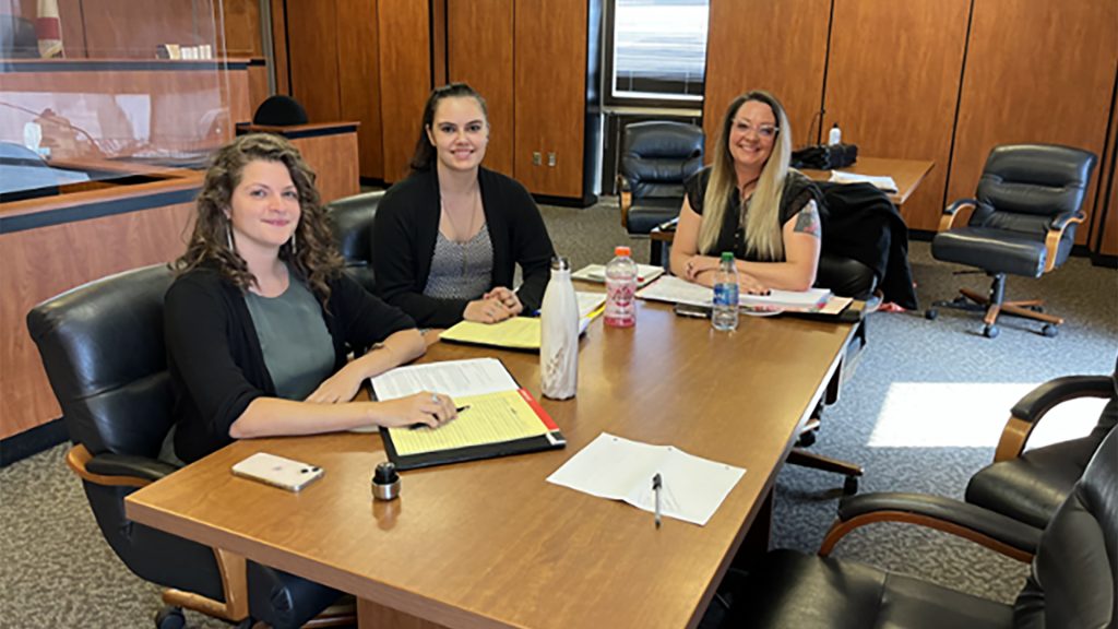 Three clinic students at a conference table in the county courthouse 