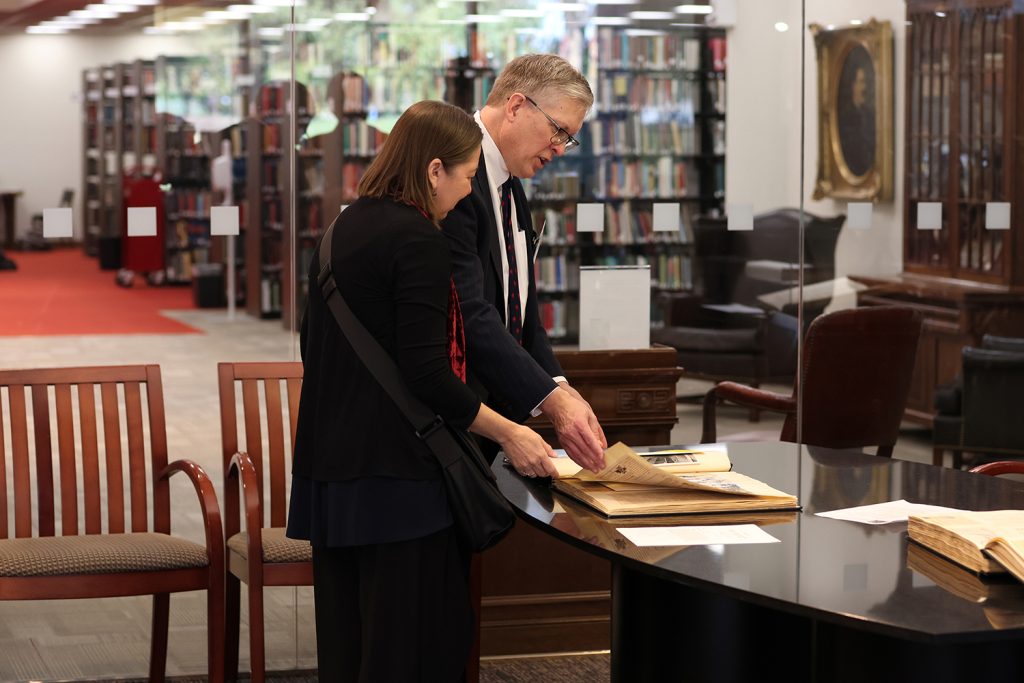 
Two former clerks of Judge Johnson review one of the scrapbooks in the Judge Frank M. Johnson, Jr. Collection in the John C. Payne Special Collections Room at Alabama Law. 