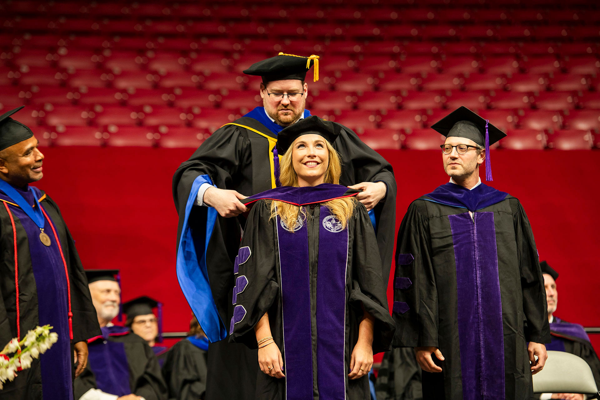 A graduate receives her hood from Professor Benjamin McMichael during the Law School commencement ceremony. 