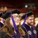 Alabama Law graduate smiles with purple tassel hanging to the side of her face.