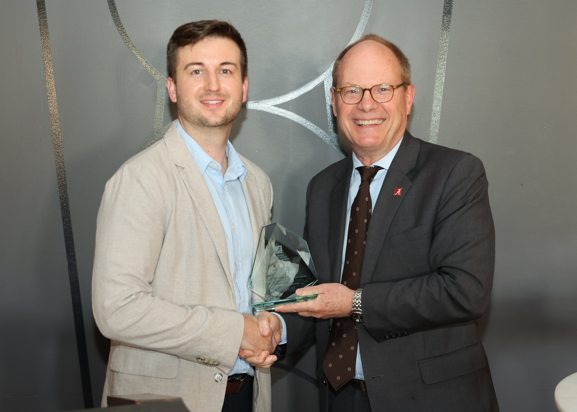 Dean Bill Brewbaker presents Judge Zachary Walden (‘16) with the 2025 Alabama Rising Young Attorney Award.