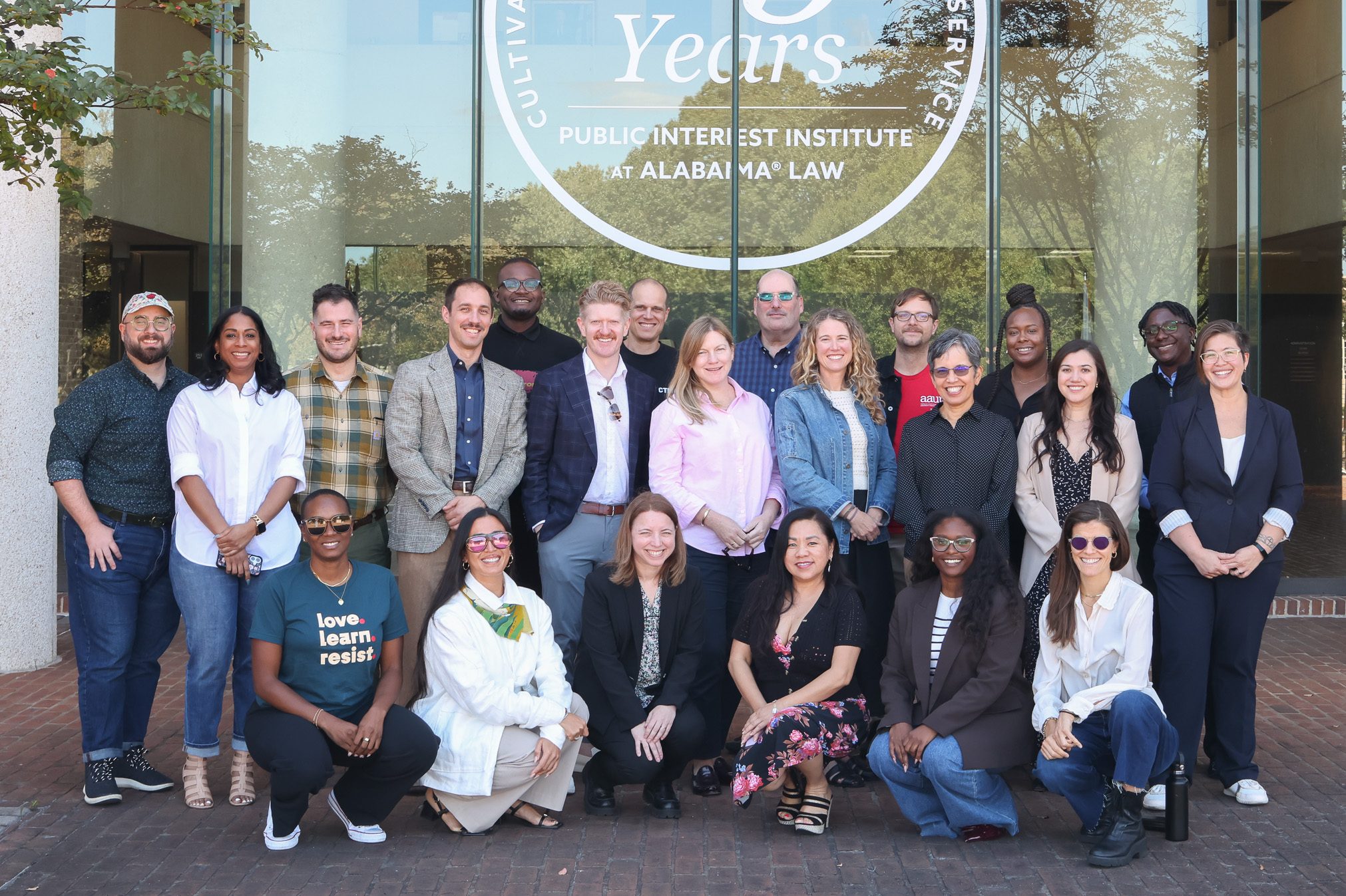 A group of people poses outside. 