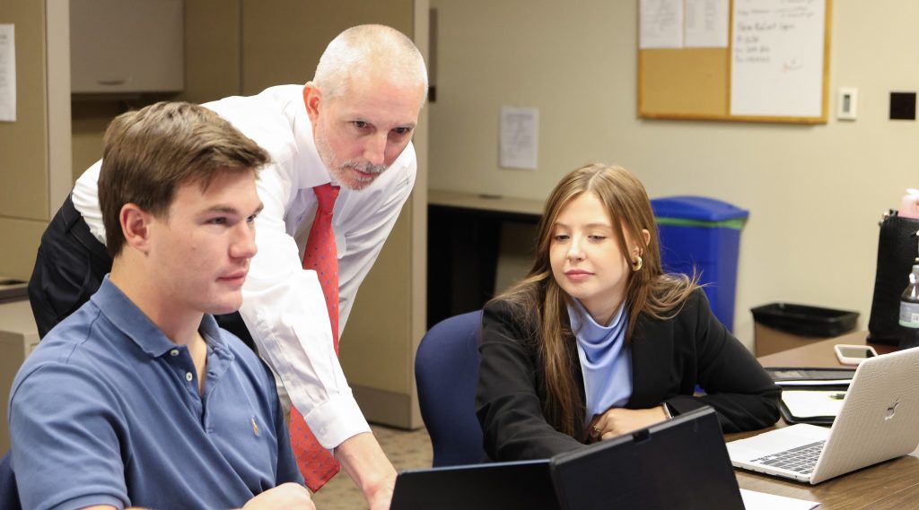 Clinic professor discusses a client's case with students,