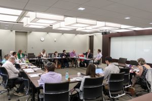 Photo of law and religion scholars sitting around a room in discussion. 